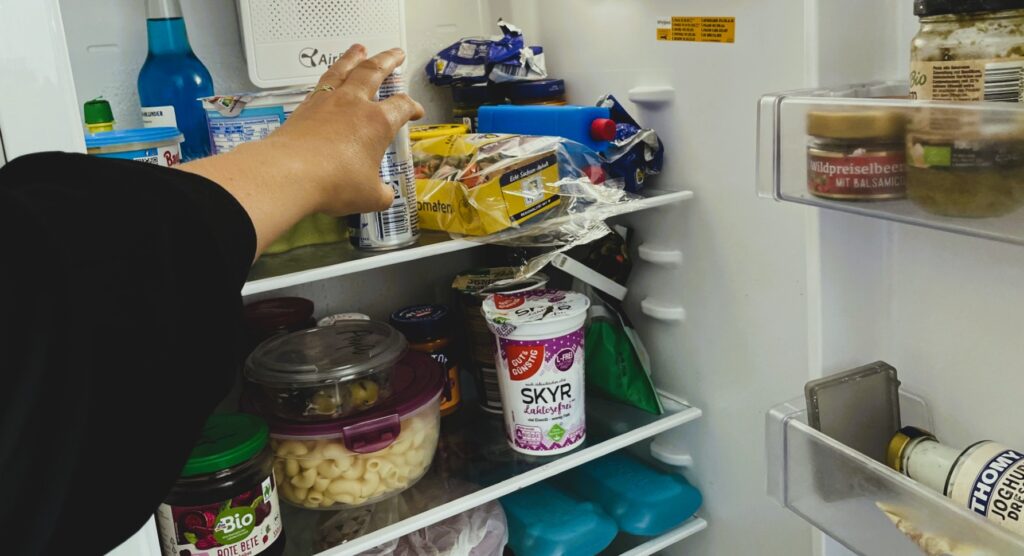 offener Kühlschrank mit Hand