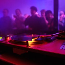 nahaufnahme-von-dj-equipment-und-den-tanzenden-leuten-im-club